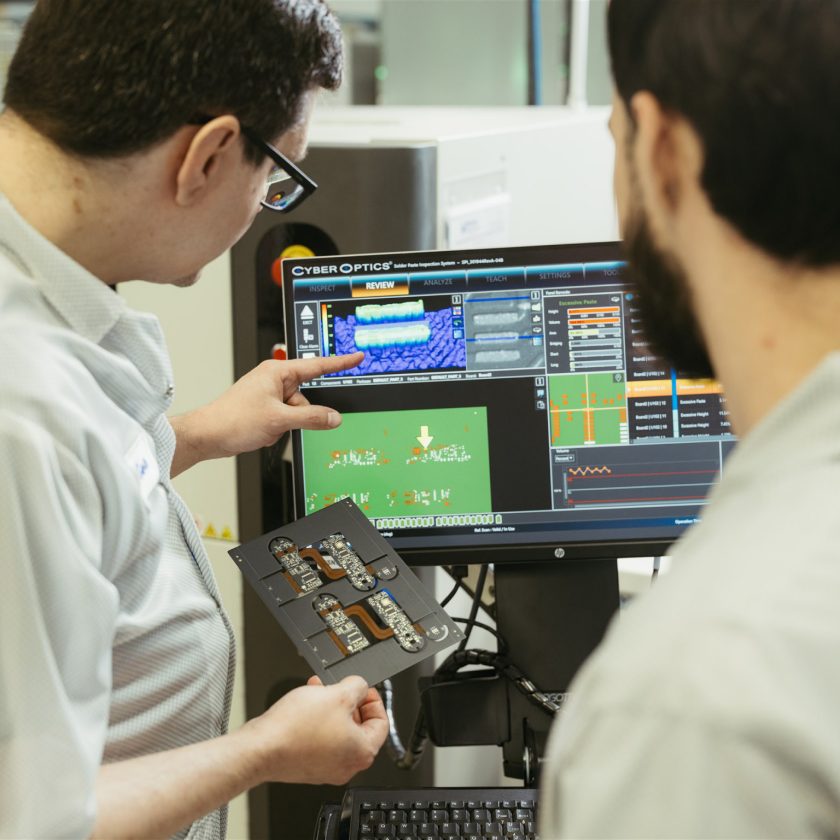 Milwaukee Electronics engineers reviewing an assembly at a workstation