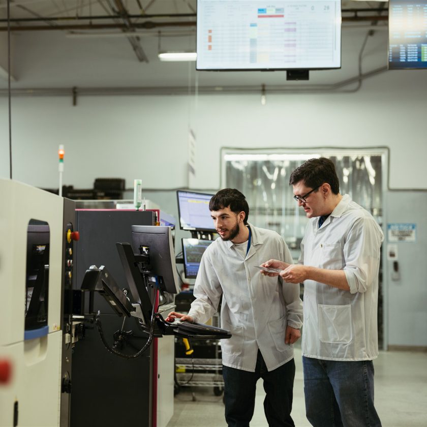 Milwaukee Electronics engineers reviewing a board at an SMT line
